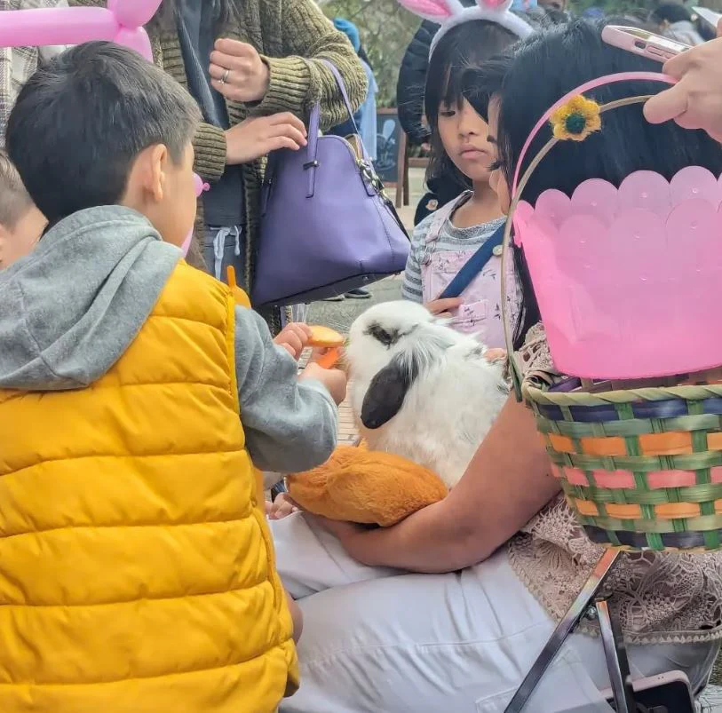 Children gathered around a spotted rescue bunny with an Easter basket