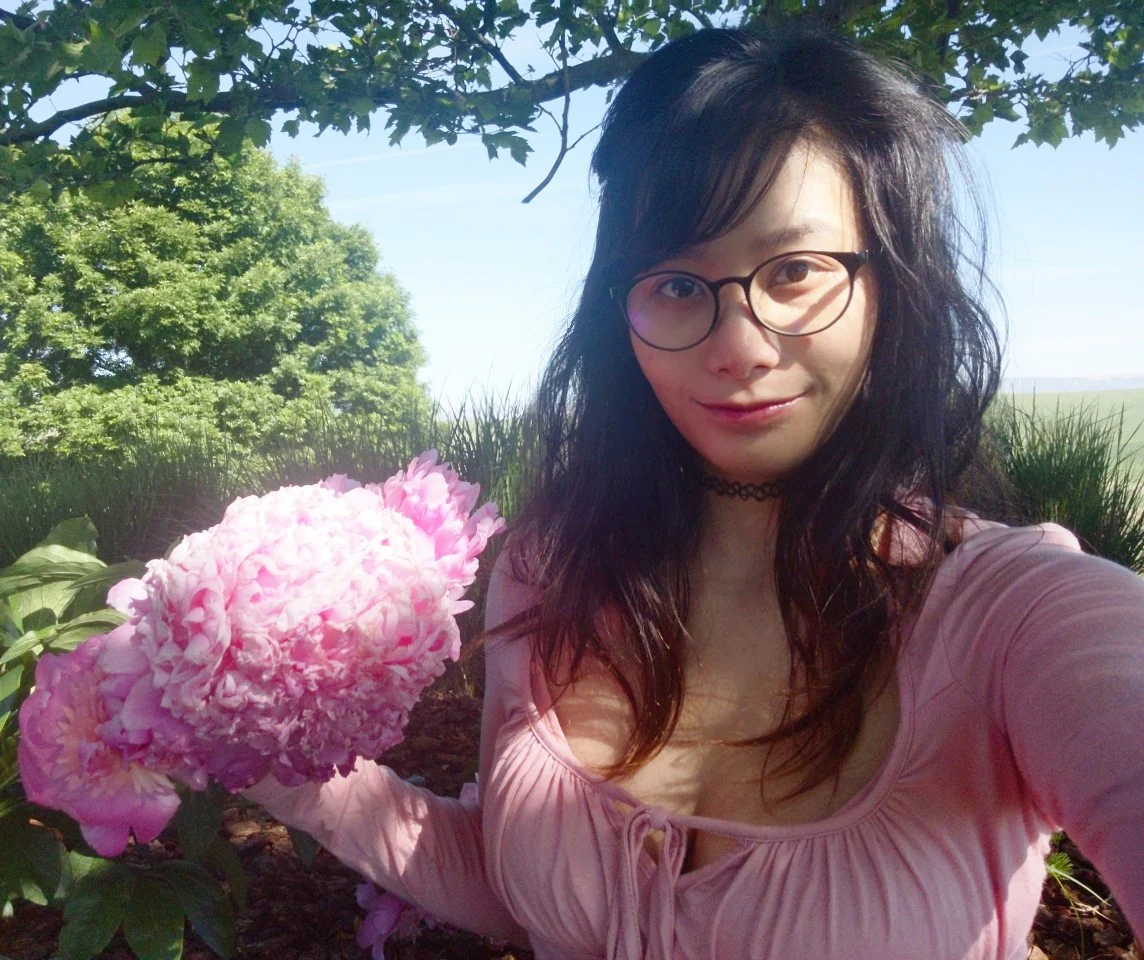 PhyTu's founder holding a pink tree peony bloom