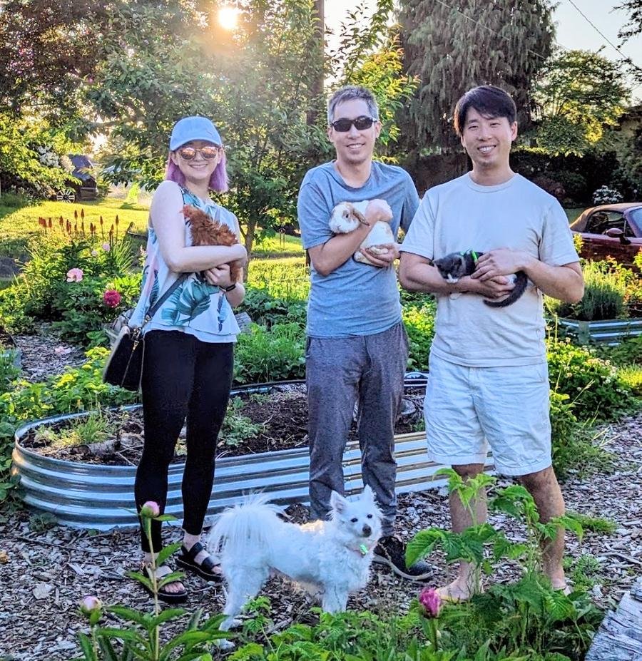 PhyTu community volunteer — people holding chickens, rabbits and kittens at golden hour in the garden