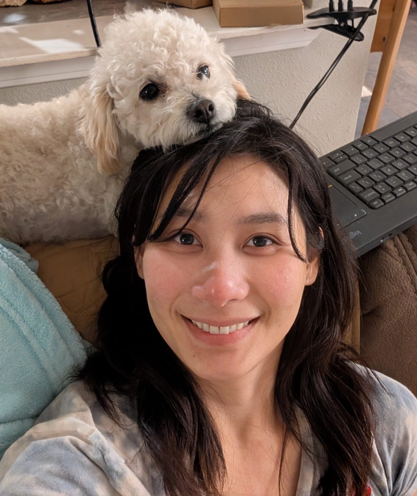 A cream poodle resting its chin on the head of PhyTu’s founder